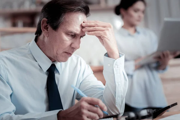 Hombre de negocios preocupado frunciendo el ceño y tocándose la frente —  Fotos de Stock