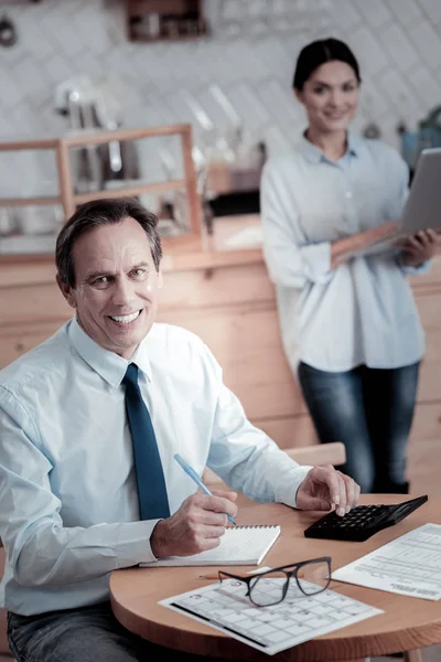 Homem positivo sorrindo enquanto uma mulher segurando um laptop — Fotografia de Stock