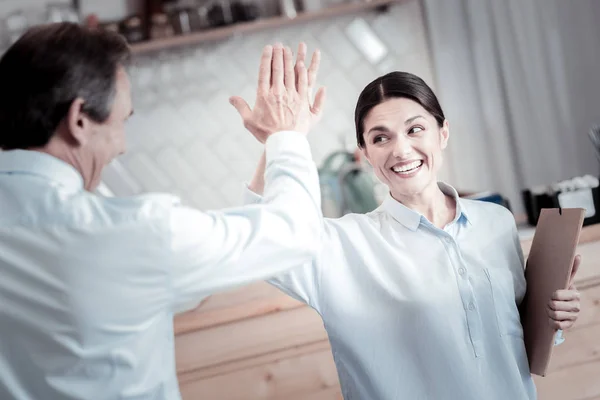 Mujer feliz sonriendo y dando cinco a un hombre con una camisa blanca —  Fotos de Stock