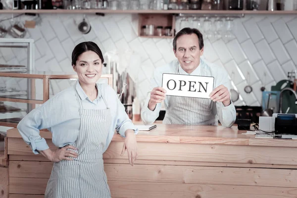 Lächelnde Kellner stehen neben der Theke und warten auf die ersten Besucher — Stockfoto