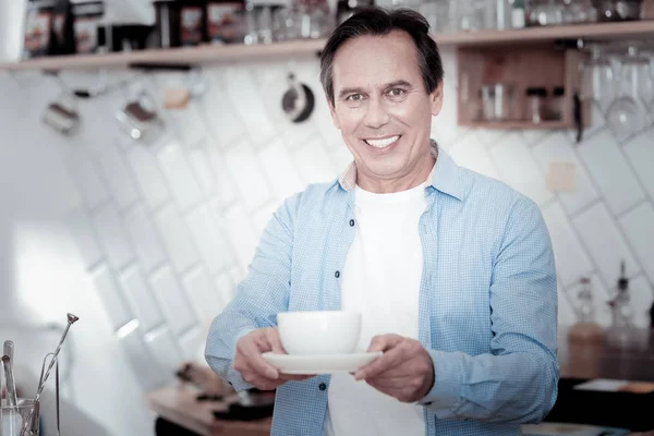 Middle aged man holding a cup of coffee and smiling — Stock Photo, Image