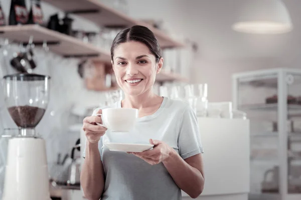 Hezká žena, pití kávy a usmívá se — Stock fotografie