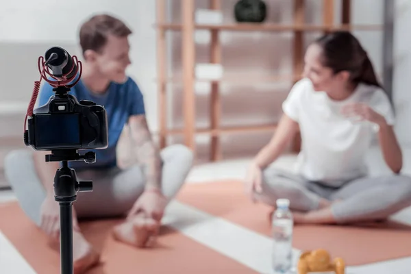 Vista de la cámara con pareja sentada en colchonetas de yoga —  Fotos de Stock