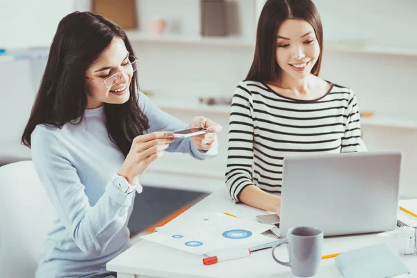 Mujer alegre positiva sosteniendo su teléfono inteligente —  Fotos de Stock