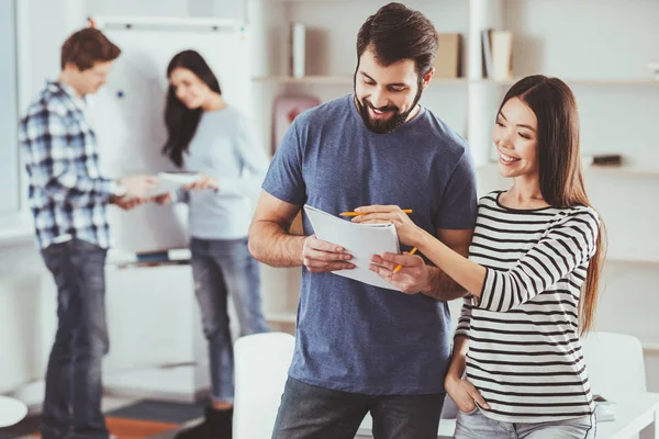 Jóvenes positivos mirando sus notas — Foto de Stock