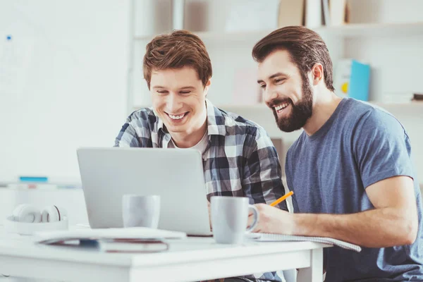 Hombres felices y alegres sentados frente a la laptop — Foto de Stock