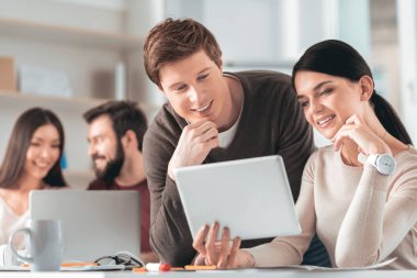 Tablet ekrana bakarak akıllı olumlu iş arkadaşları