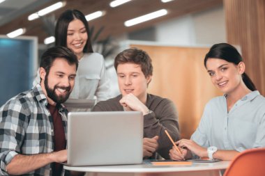 Belgili tanımlık laptop önünde oturan güzel genç insanlar