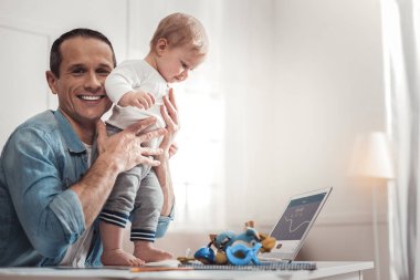 Mutlu neşeli adam çocuğunu tutan