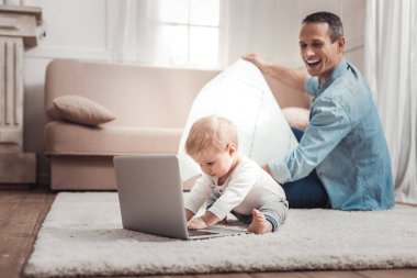 Bir dizüstü bilgisayar kullanarak neşeli pozitif çocuk