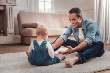 Çocuğunu gülümseyerek mutlu bir güzel adam