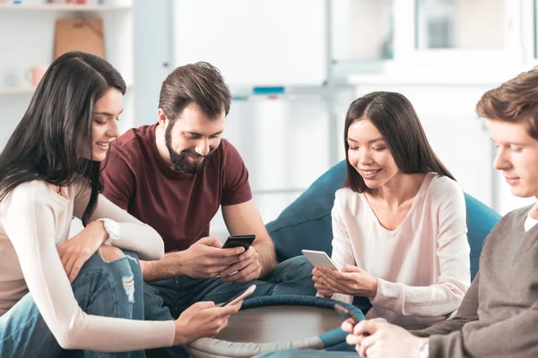 Delighted positive people using their smartphones