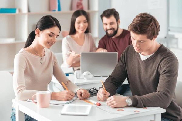 Estudantes inteligentes agradáveis fazendo sua tarefa em casa — Fotografia de Stock