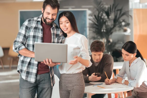 Sakallı yakışıklı bir dizüstü bilgisayar holding