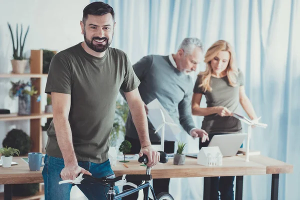 Jovial colega masculino promocionando bicicleta — Foto de Stock