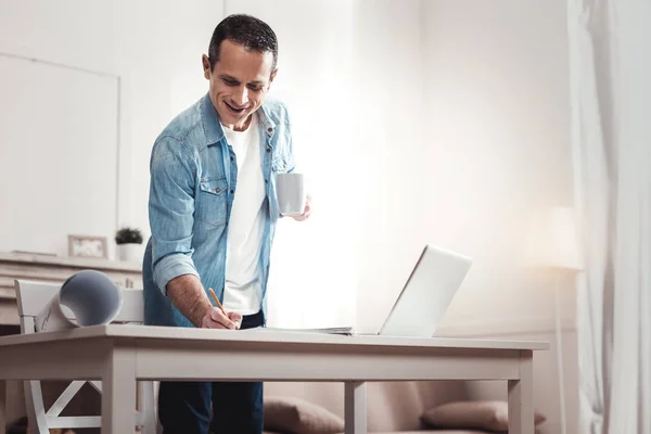 Feliz hombre alegre sosteniendo una taza — Foto de Stock