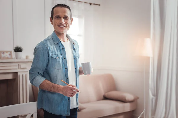 Hombre feliz positivo sosteniendo un lápiz — Foto de Stock