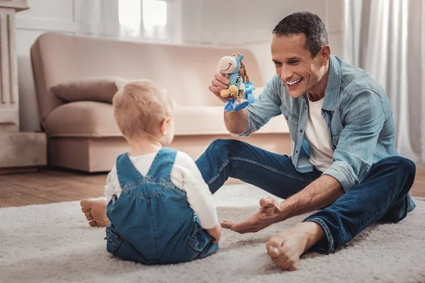 Encantado hombre agradable jugando con su bebé — Foto de Stock