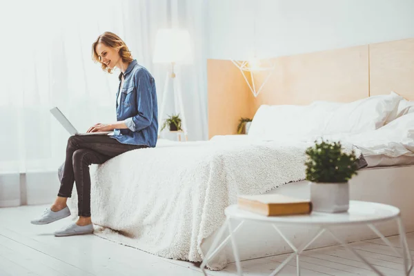 Schönes Mädchen sitzt auf ihrem Bett — Stockfoto