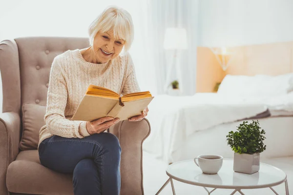 Pleased mature woman reading book — Stock Photo, Image