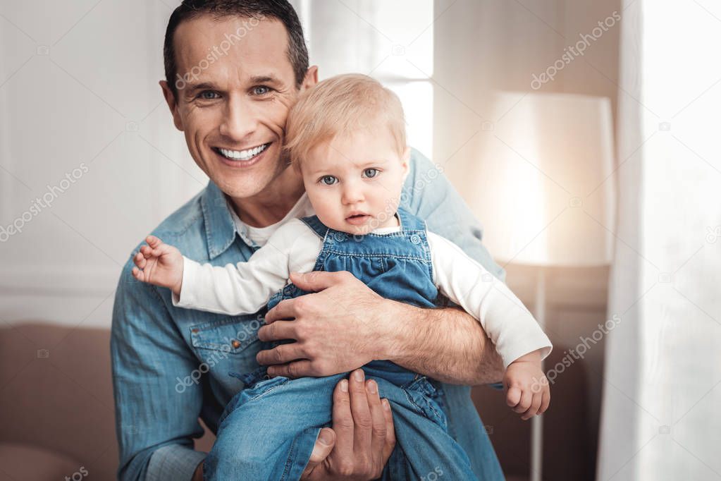 Joyful nice man showing his child