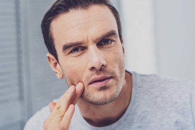 Esmer adam gri gömlek duygu düşünceli giyiyor