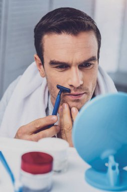 Adamın yüzüne dikkatle banyoda tıraş