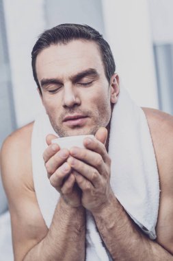 Sakin adam elinde bir fincan kahve ile ısınma