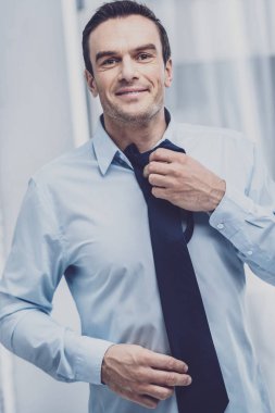 Neşeli adam bir takım elbise için kravat seçme