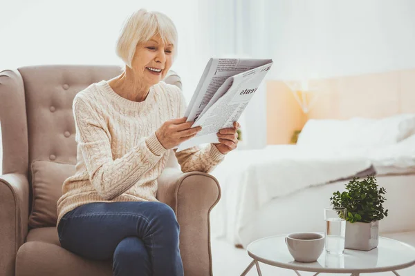 Позитивный восторг зрелая женщина читает газету — стоковое фото