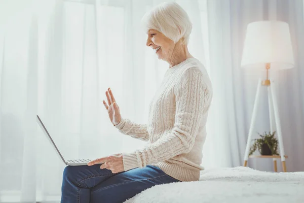 Щаслива старша жінка спілкується онлайн — стокове фото