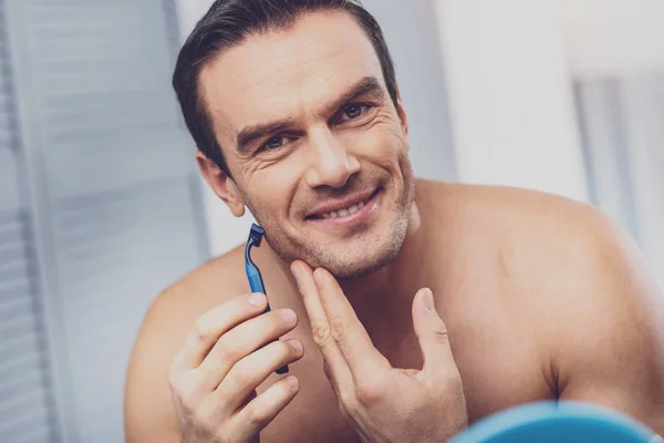 Zralý muž s úsměvem při holení tváře — Stock fotografie