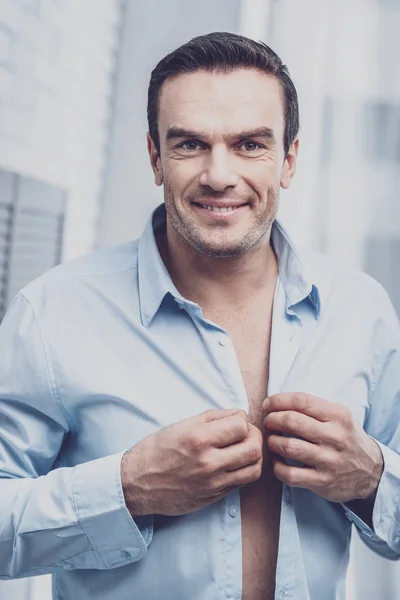 Homem positivo experimentando uma camisa formal — Fotografia de Stock