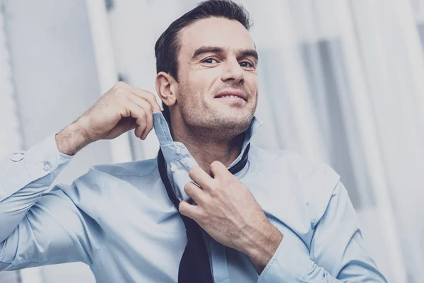 Charismatic businessman tying his tie — Stock Photo, Image