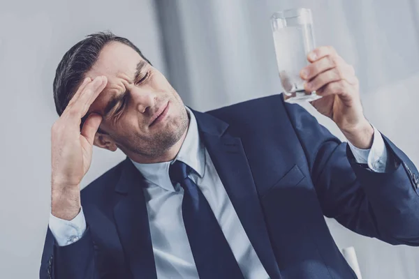 Entrepreneur fatigué tenant un verre d'eau — Photo