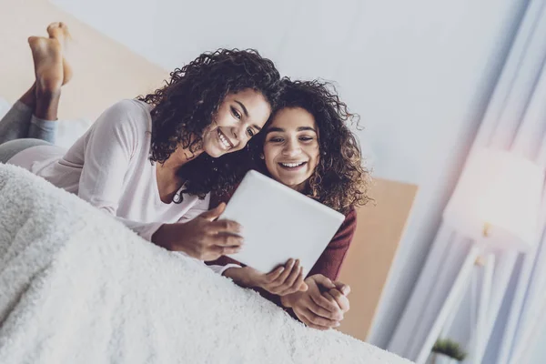 Increíbles amigos acostados en una cama acogedora — Foto de Stock