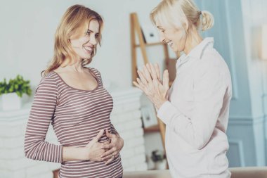 Neşeli genç kadın hamileliği hakkında söylüyorum