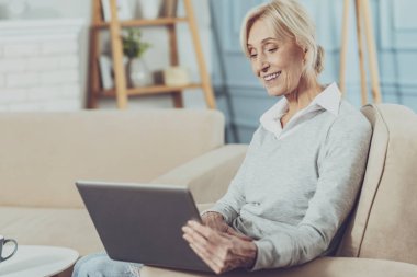 Dizüstü bilgisayar ekranına bakarak mutlu memnun kadın