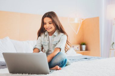 Çizgi film izlerken gülümseyen dostane genç kız