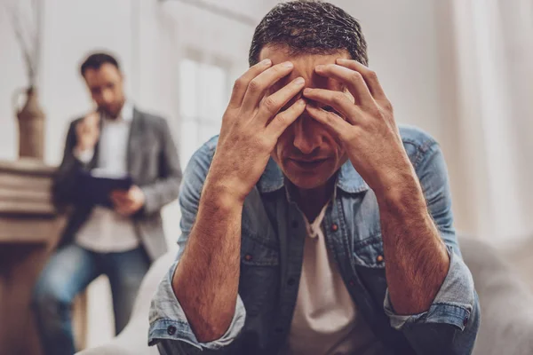 Hombre serio tocándose la frente — Foto de Stock