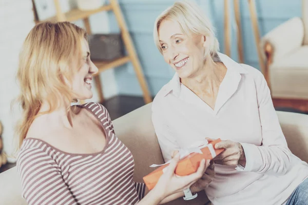 Delighted aged woman giving a present to her daughter — Stock Photo, Image