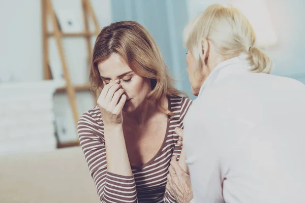 Unglückliche alte Frau berührt den Nasenrücken — Stockfoto