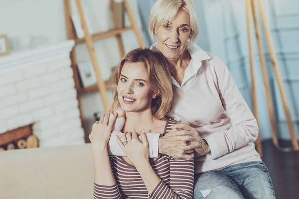 Cheerful senior woman hugging her daughter — Stock Photo, Image