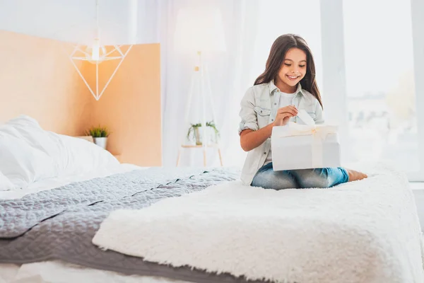 Chica responsable de recibir regalo de cumpleaños en el dormitorio de luz — Foto de Stock