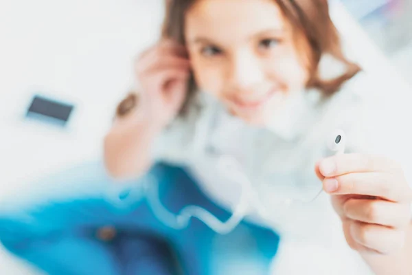 Schoolmeisje luisteren naar nieuwe hits met moderne koptelefoon — Stockfoto