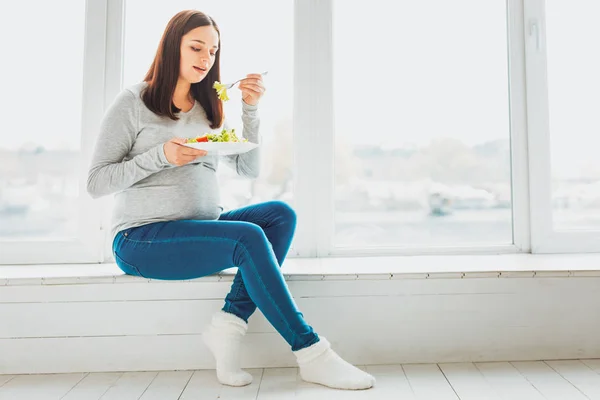 Mujer embarazada de cabello oscuro que come alimentos saludables — Foto de Stock
