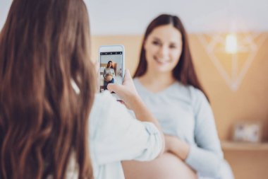 Küçük kızının hamile annesi bir fotoğraf çekici arkadan görünüş