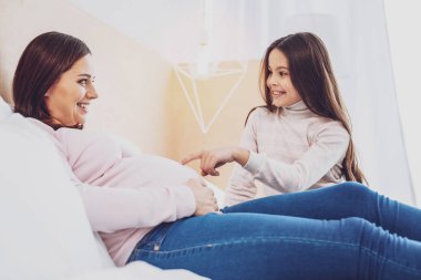 Anne karnı işaret meraklı küçük kızı