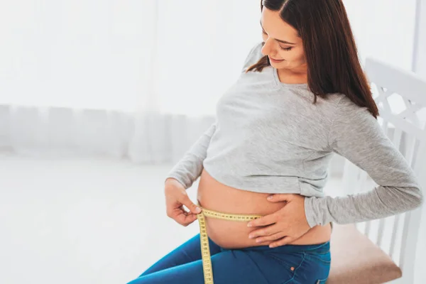 Mujer sonriente satisfecha esperando su primer hijo — Foto de Stock