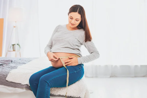 迷人的漂亮期待的女人坐在大双人床上 — 图库照片